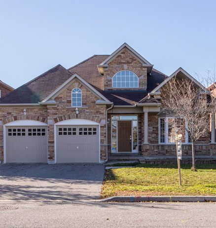 A large brick house with two garage doors.