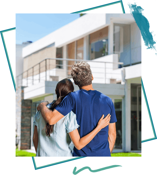 A couple is standing in front of their home.